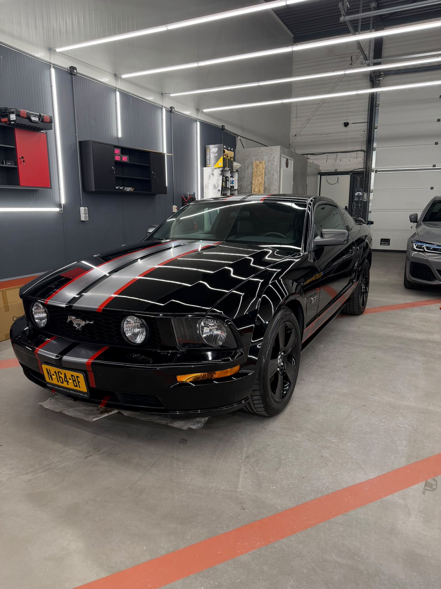 Gepolijste zwarte Ford Mustang GT in de werkplaats